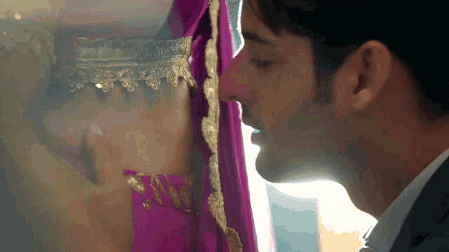 a man kissing a woman in a purple dress