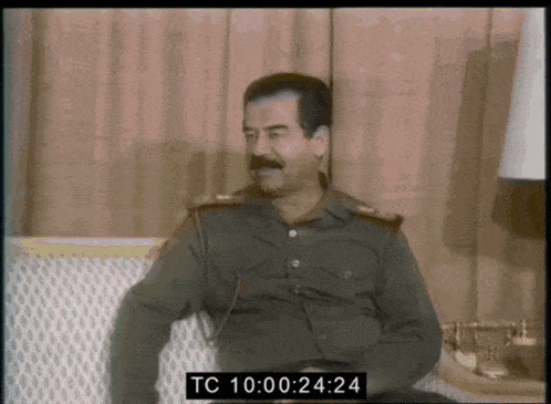 a man sitting on a couch with the time tc 10 00 24 24 on the bottom right