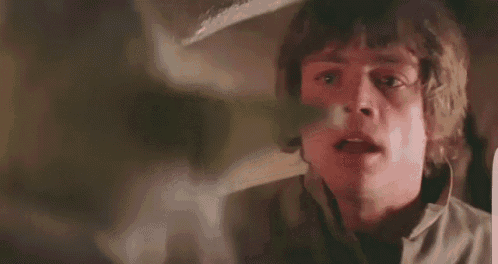 a close up of a man 's face with his mouth open in a room .