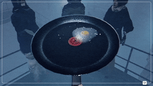 a frying pan with a fried egg and a slice of meat in it