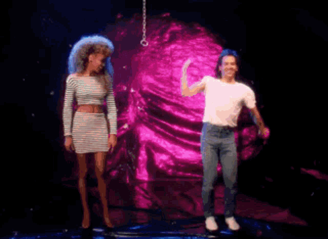 a man and a woman are dancing on a stage with a pink background