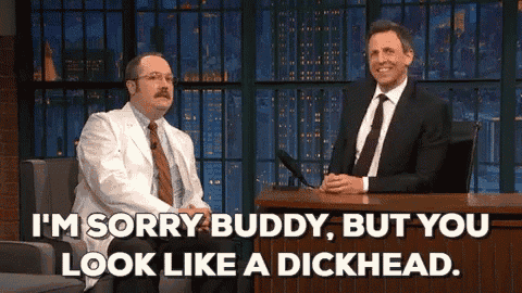 two men are sitting at a table and one of them says i 'm sorry buddy , but you look like a dickhead