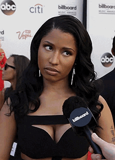 a woman is being interviewed with a microphone that says billboard on it