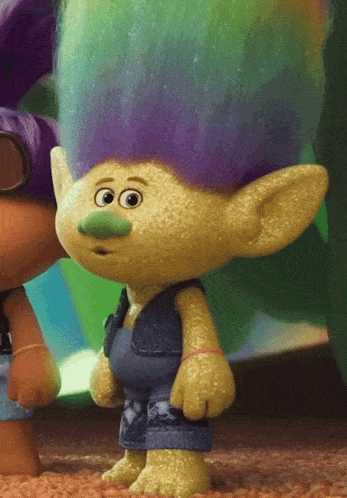 a troll with purple hair and green nose is standing next to another troll