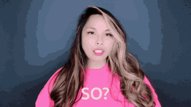 a woman wearing a pink sweater that says so on it