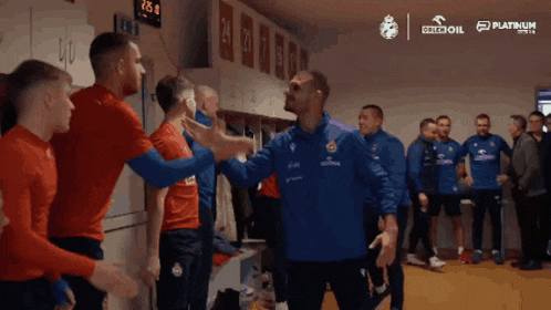 a group of soccer players in a locker room with a platinum logo