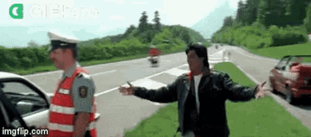 a man is talking to a police officer on the side of a highway .