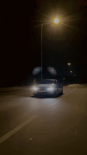 a car is driving down a street at night with a license plate that says ' jc ' on it