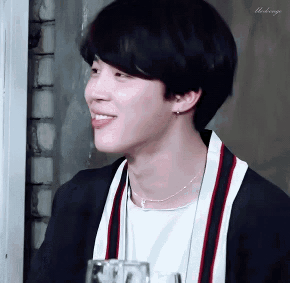 a close up of a person wearing a necklace and a sweater