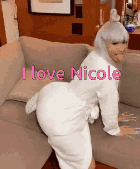a woman in a white robe is kneeling on a couch with the words " i love nicole " written above her