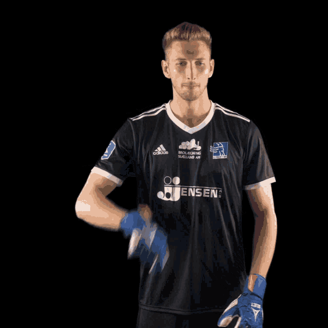 a soccer player wearing a black adidas jersey
