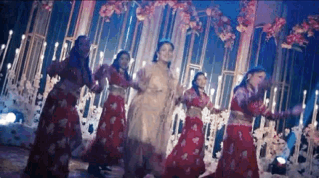 a group of women are dancing on a stage at a wedding .