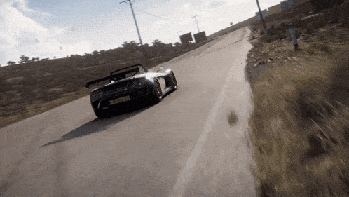 a black sports car is driving down a road and has a license plate that says sgc - snm
