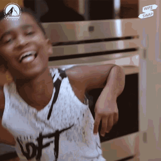a boy wearing a white tank top that says loft