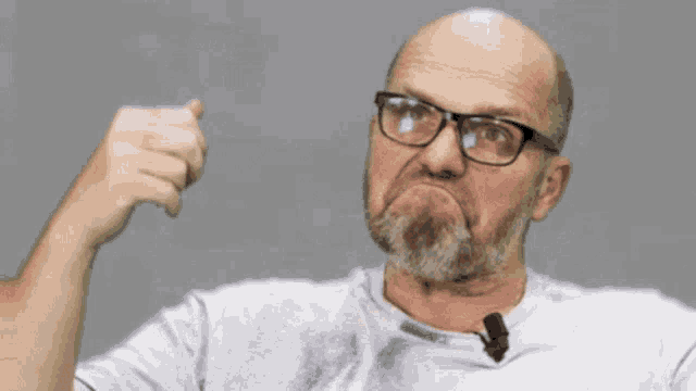 a bald man with glasses and a beard is making a face