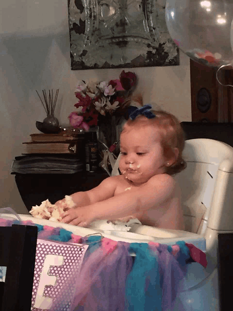 a baby in a high chair with a sign that says e