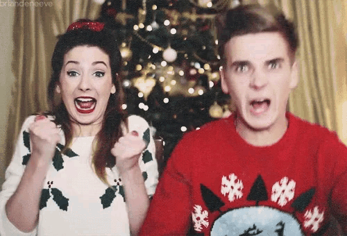 a man and a woman wearing ugly christmas sweaters