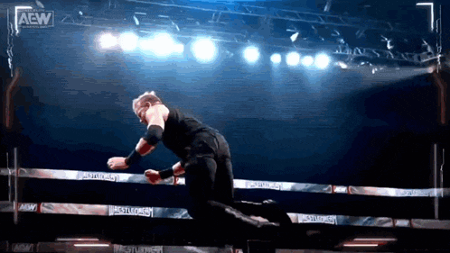 a wrestler in a ring with a aew logo