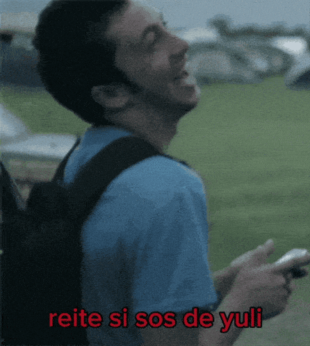 a man with a backpack is laughing with the words reiter si sos de yuli written below him