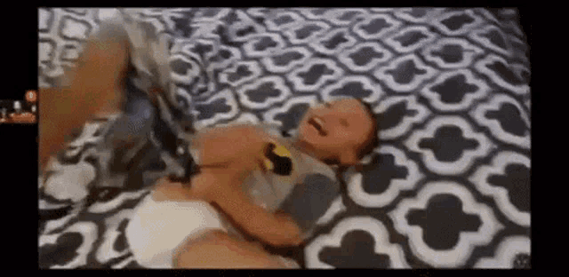 a baby wearing a diaper is laying on a bed .