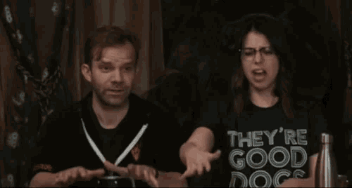a man and a woman are shaking hands and the woman is wearing a t-shirt that says they 're good dogs