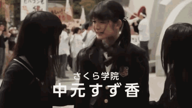 a girl in a school uniform is talking to another girl with chinese writing on the bottom