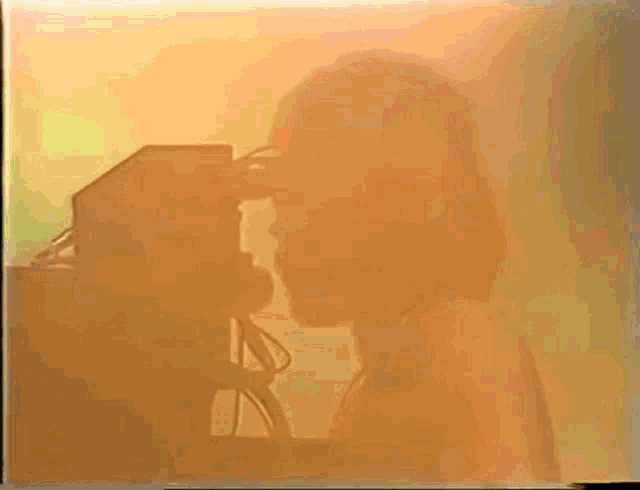 a silhouette of two people kissing in front of a yellow background