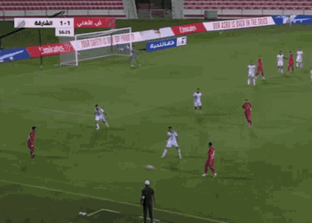 a soccer game is being played in a stadium with emirates advertisements on the sidelines