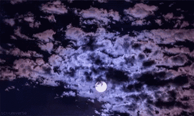 a full moon is shining through the clouds in the night sky