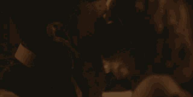 a man and a woman are hugging each other in a dark room .