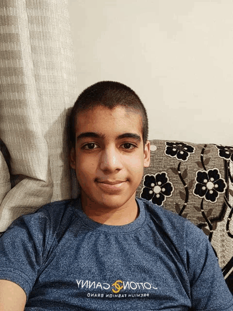 a young man wearing a blue t-shirt that says yииаэ sиoto