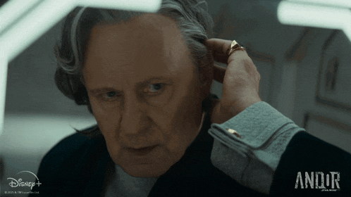a man is adjusting his earring in a disney plus ad
