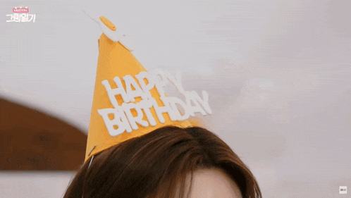 a woman wearing a yellow hat that says happy birthday on it