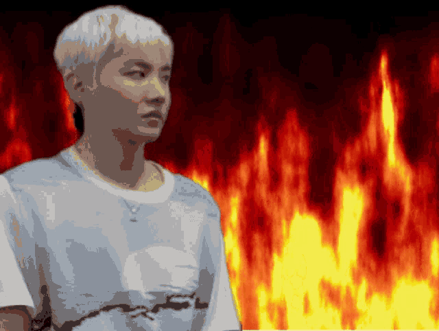 a man with white hair is standing in front of a fire background .