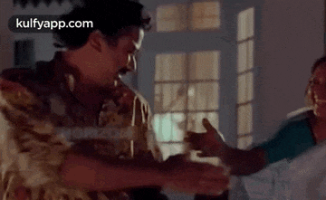 a man and a woman are dancing in a room with a window in the background .