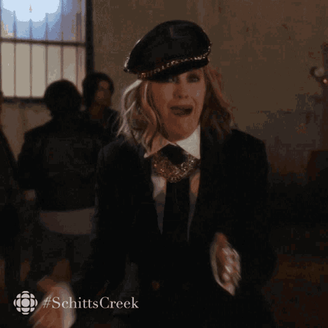 a woman wearing a hat and a suit with the hashtag schitts creek on the bottom