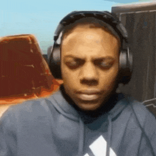 a man wearing headphones and a hoodie with an adidas logo on it