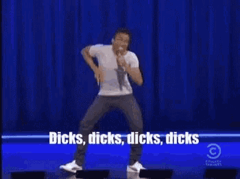 a man is dancing on a stage with the words dicks dicks dicks dicks written above him .