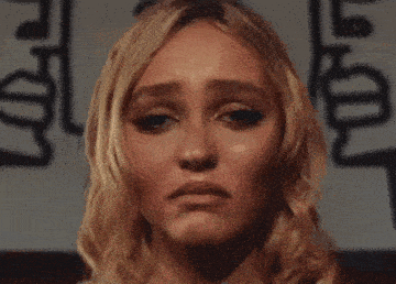 a close up of a woman 's face with a sad look on it .