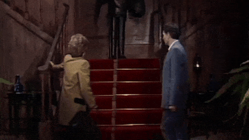 a man and woman are walking down a set of stairs .