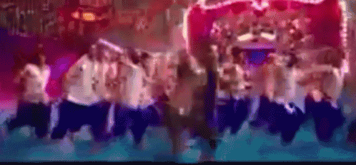 a group of people are dancing on a stage in front of a crowd .