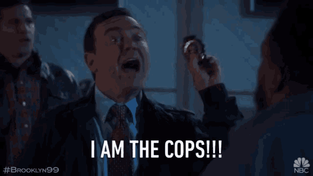 a man in a suit and tie is holding a badge and saying i am the cops