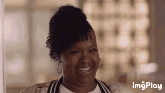 a woman is smiling and making a funny face while wearing earrings .