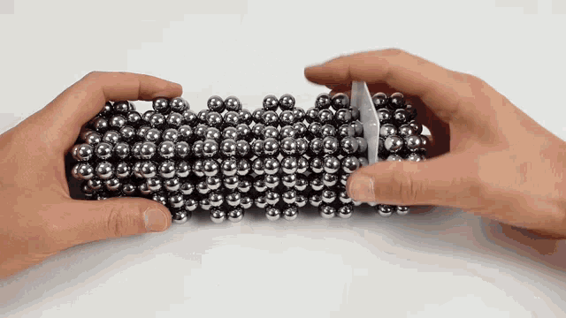 a person is holding a bunch of metal balls