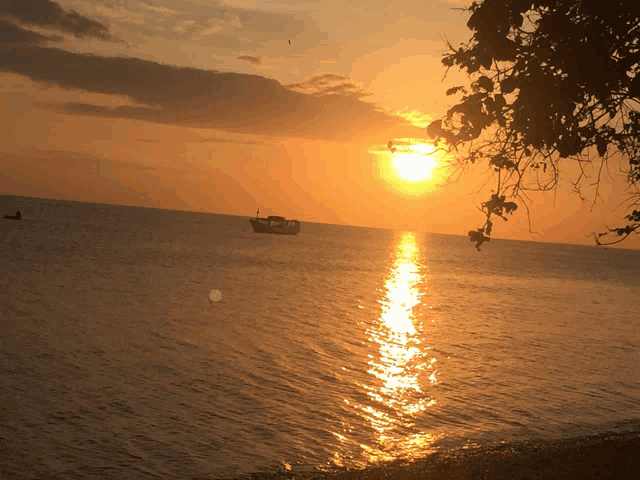 a sunset with a boat in the water