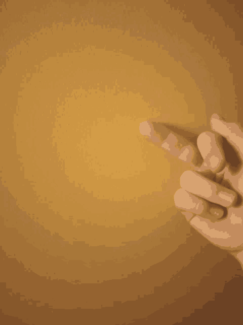 a person 's hand is pointing to a yellow background