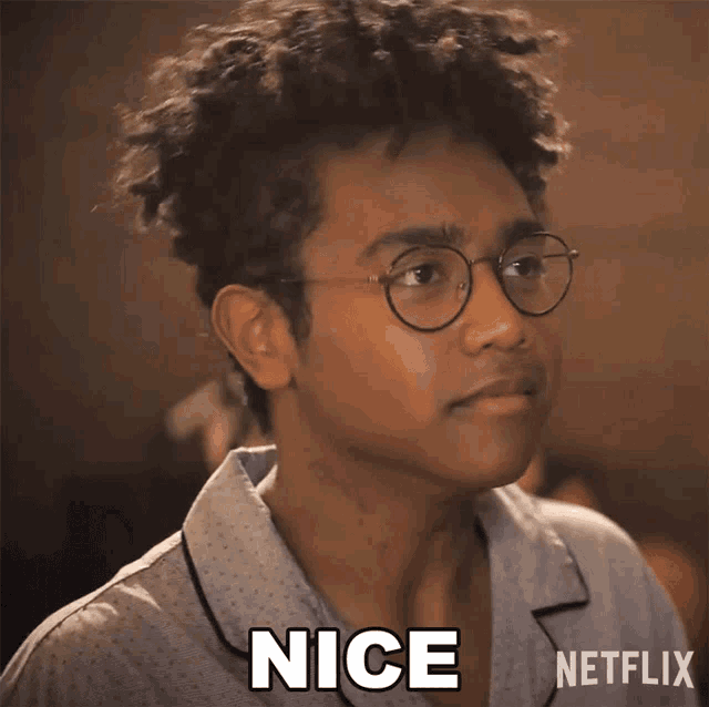 a young man wearing glasses and a shirt that says nice