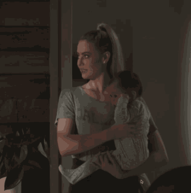 a woman in a dallas shirt holds a baby in her arms