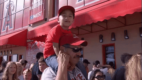a man is carrying a child on his shoulders in front of a building that says cal