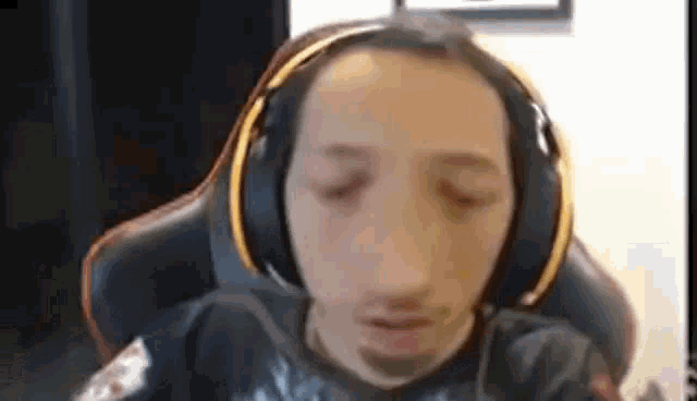 a man is wearing headphones and sitting in a chair .